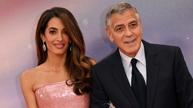 Amal and George Clooney smiling on the red carpet in 2025.