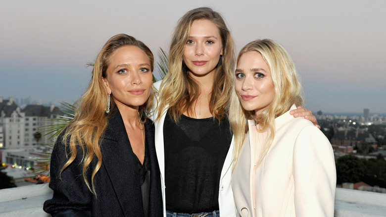 Mary-Kate Olsen, Elizabeth Olsen, and Ashley Olsen smile together