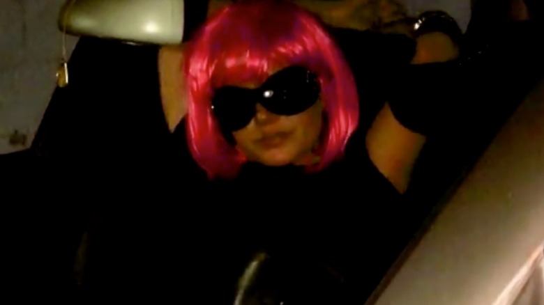 Britney Spears in passenger seat of car wearing pink wig
