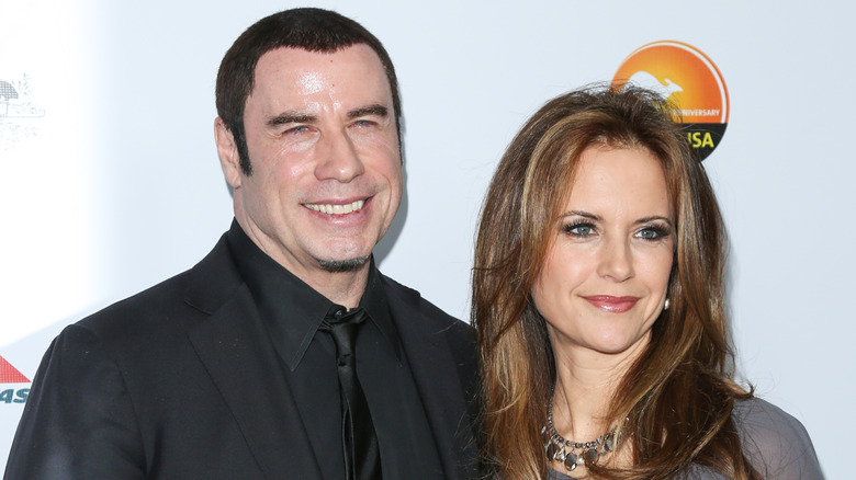 John Travolta and Kelly Preston smiling on step-and-repeat
