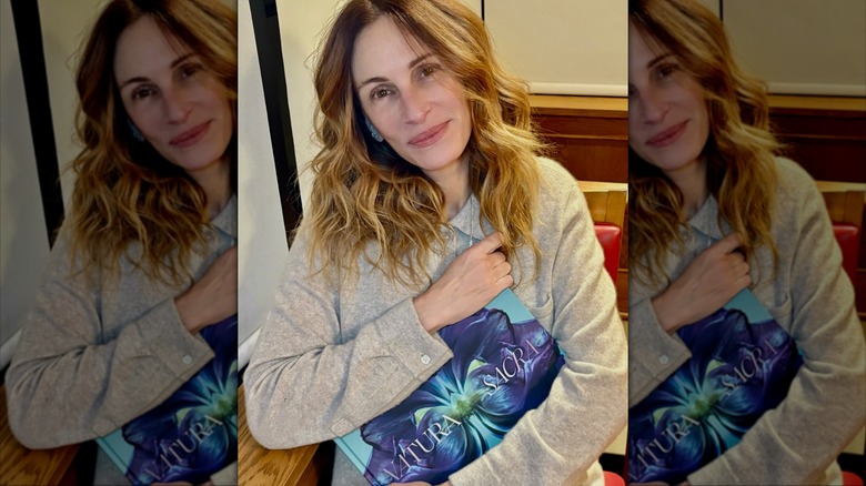 Julia Roberts makeup-free holding a book to her chest