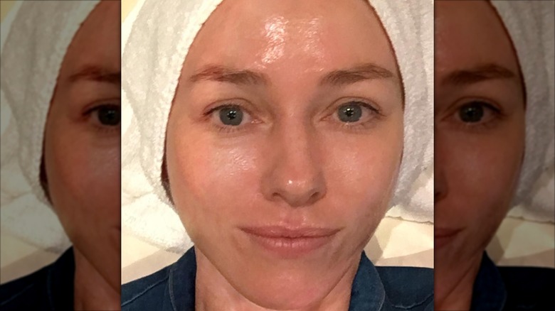 Naomi Watts in a close-up shot with her hair up in a towel