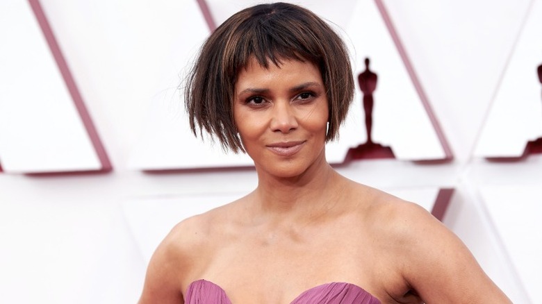 Halle Berry posing at the Oscars in a short wig with bob and micro fringe