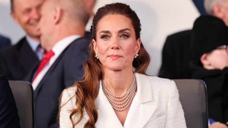 Kate Middleton pursing her lips in a white blazer