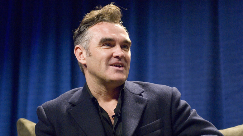 Morrissey giving an interview in a black suit