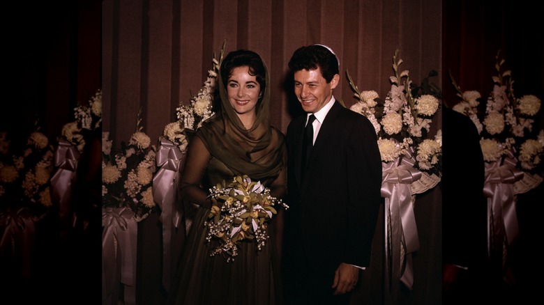 Elizabeth Taylor in her green wedding dress beside Eddie Fisher