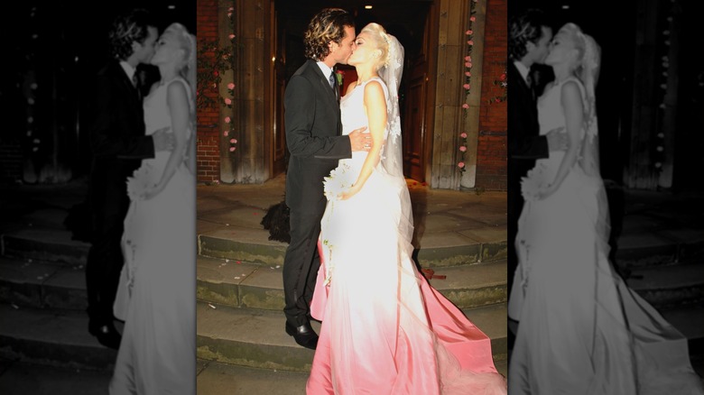 Gwen Stefani kissing Gavin Rossdale in her white-pink wedding gown
