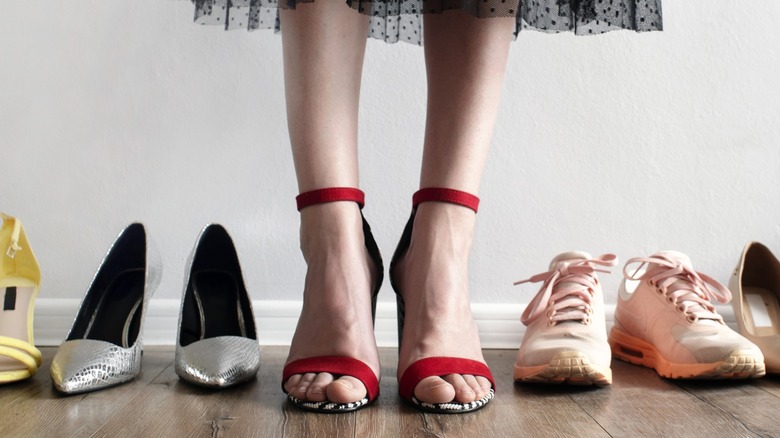 An array of different shoe styles with a woman wearing one pair