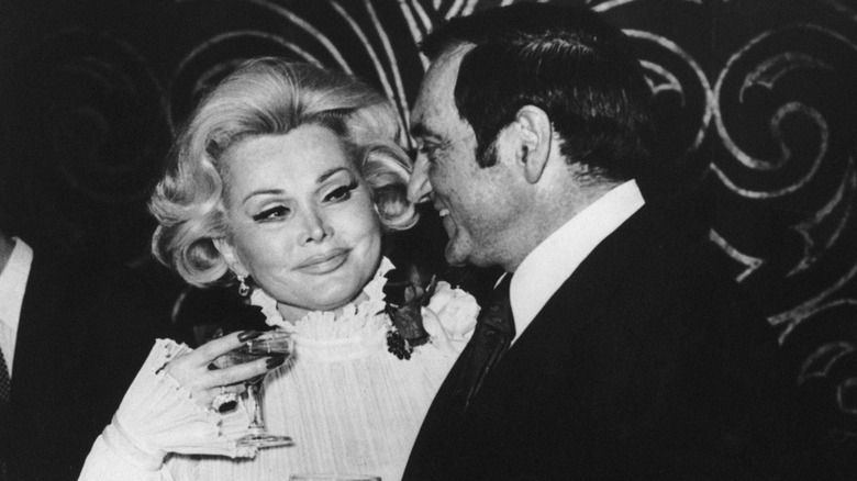 Zsa Zsa Gabor holding a cocktail and smiling at her sixth husband, Jack Ryan.