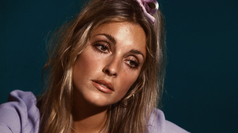 Sharon Tate wearing a ribbon in her hair and looking pensive
