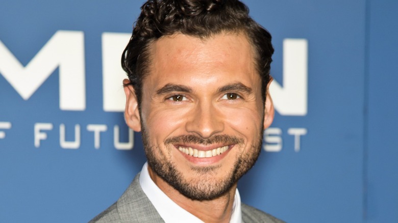 Closeup of Adan Canto smiling on step-and-repeat