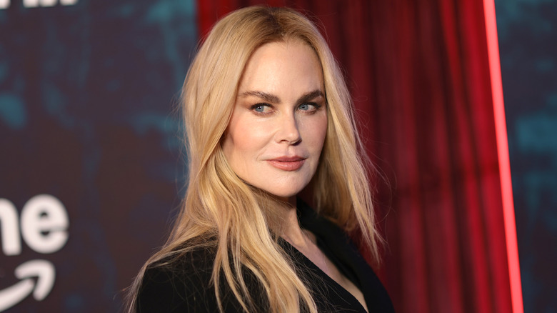 Nicole Kidman in black against a red background