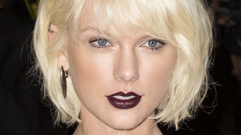 A closeup of Taylor Swift in dark lipstick