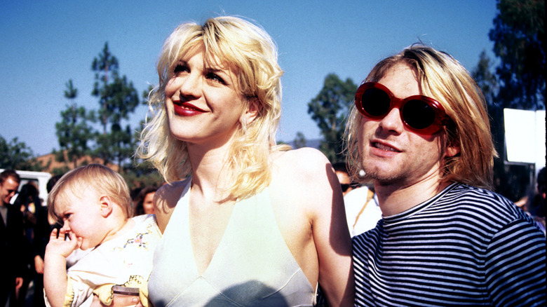 Kurt Cobain beside Courtney Love holding Frances Bean Cobain