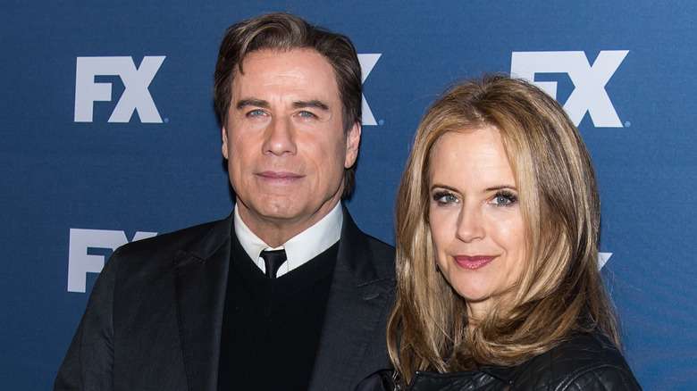 John Travolta with Kelly Preston against blue background
