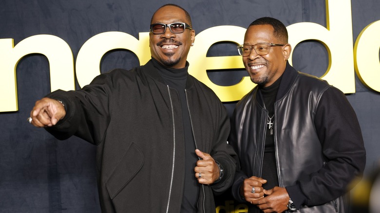 Eddie Murphy and Martin Lawrence wearing all black and joking around at the premiere for Being Eddie.