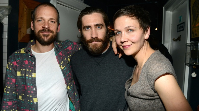 Peter Sarsgaard, Jake Gyllenhaal, and Maggie Gyllenhaal posing with their arms around each other.