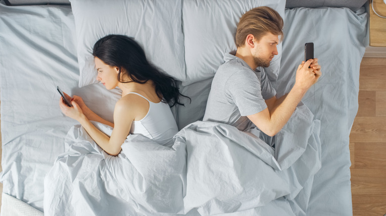 couple in bed on phones