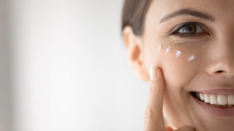Woman applying moisturizer