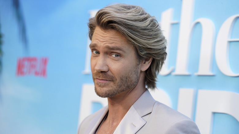 Close-up Chad Michael Murray posing and smirking in a gray suit.