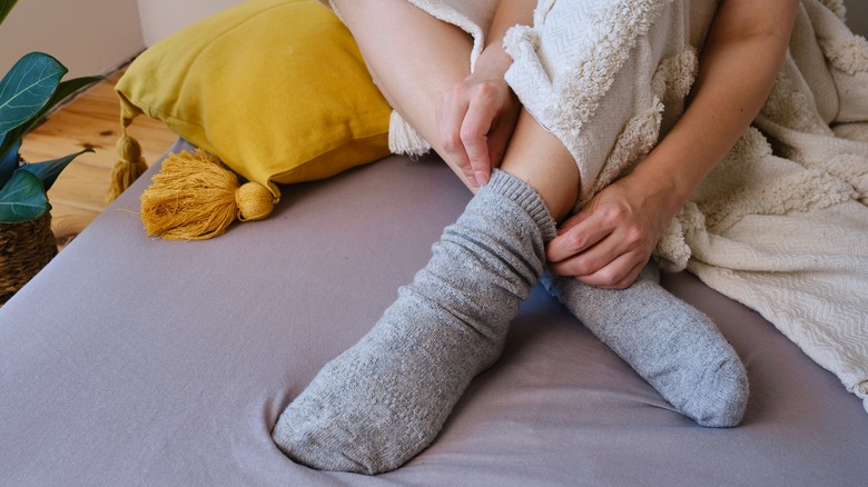 woman putting on socks