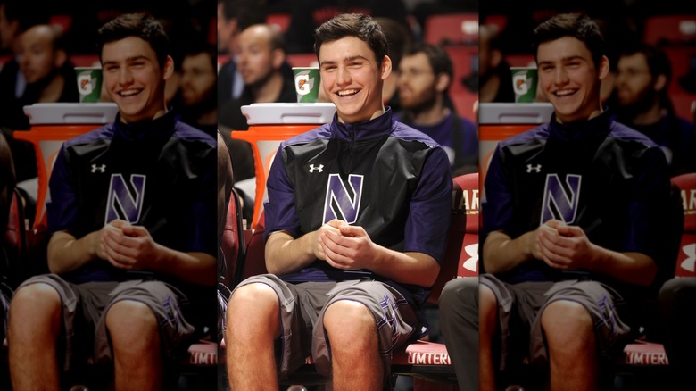 Charlie Hall smiling in a Northwestern shirt on the bench at a basketball game.