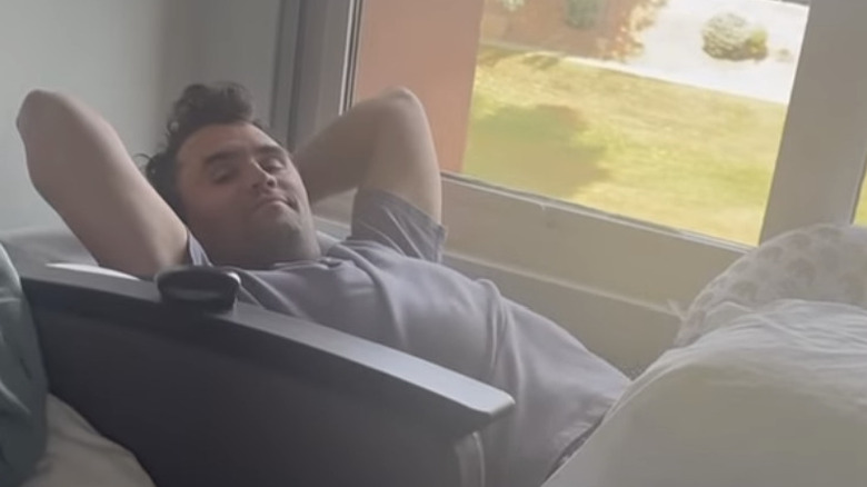Charlie Kirk lounging on a bed