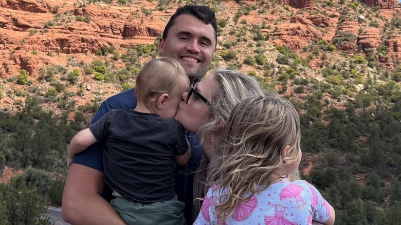 Erika and Charlie Kirk posing for a photo with their two kids