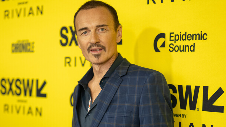 Julian McMahon in front of yellow backdrop