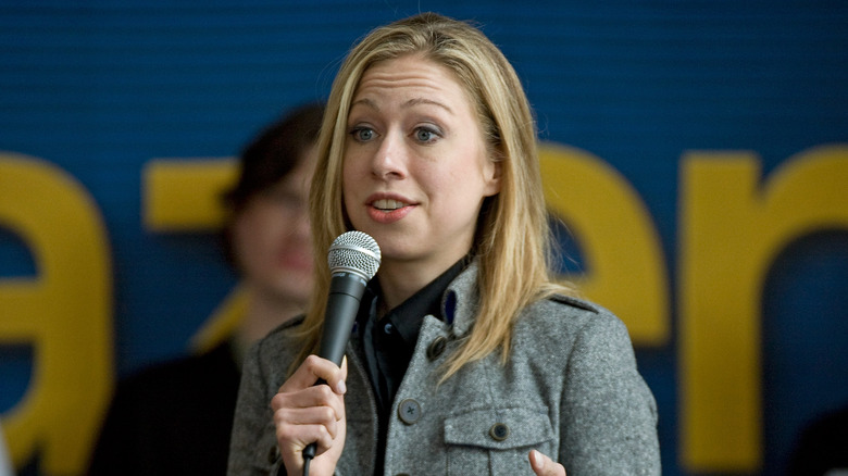 Chelsea Clinton speaking into a microphone at a university