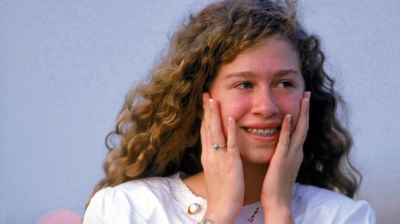 Chelsea Clinton holding her face and smiling
