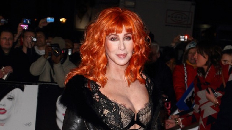 Cher with red hair and a black lingerie outfit