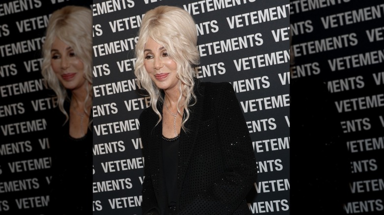 Cher wore a black outfit and her blond hair in an updo