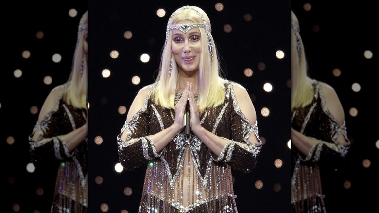 Cher wore a sparkly crop top with blond hair and a sparkly headpiece