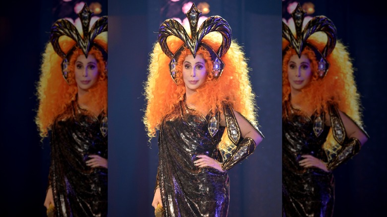 Cher in a bright orange wig with headpiece