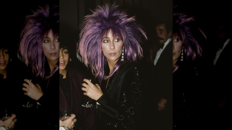 Cher in a purple wig and black jacket