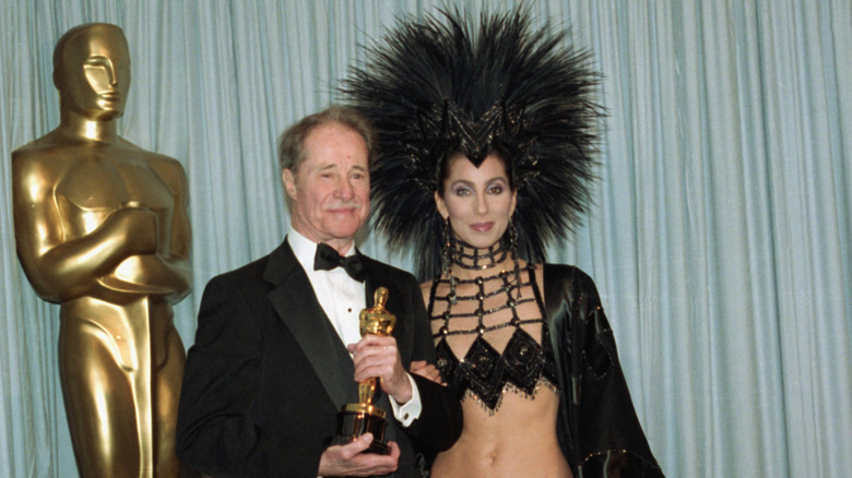 Don Ameche holding his Oscar and standing next to Cher