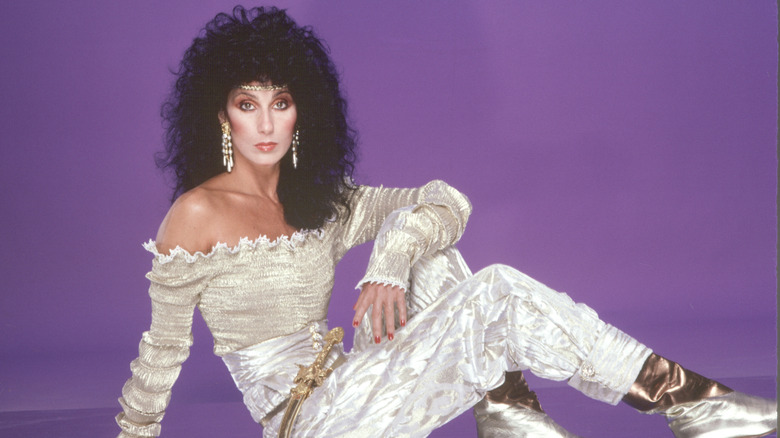 Cher poses in an off-the-shoulder white outfit