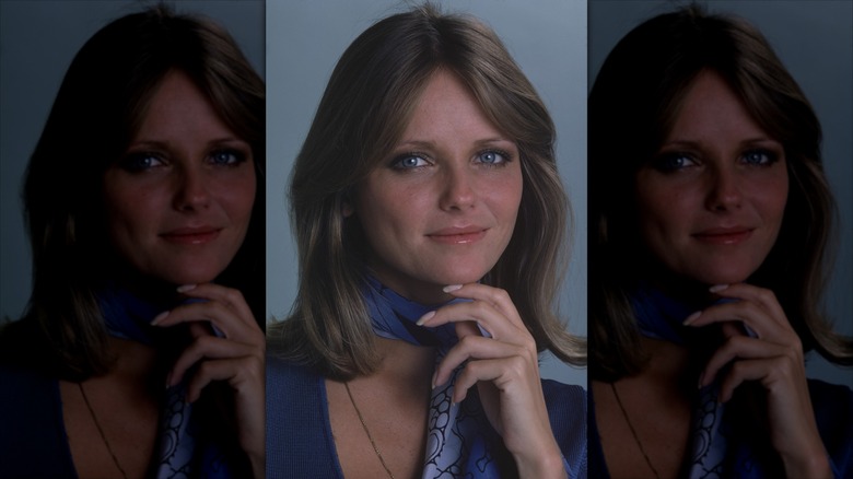 Cheryl Tiegs posin with her hand under her chin in a blue v-neck and patterned ascot for Womens Own magazine in the mid 1970s