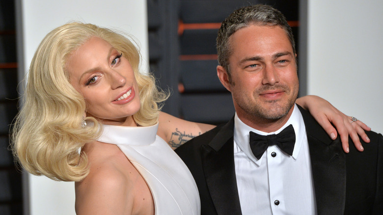 Lady Gaga with her arm around Taylor Kinney
