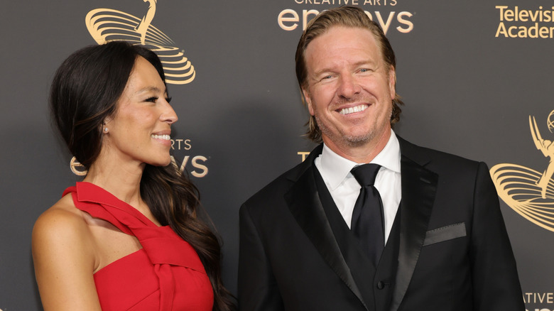 Joanna Gaines looking and smiling at Chip Gaines while he smiles at the camera