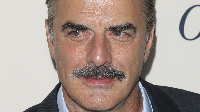 Chris Noth smiles at an event