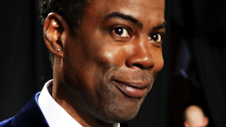 Chris Rock smiling behind the stage at the Oscars