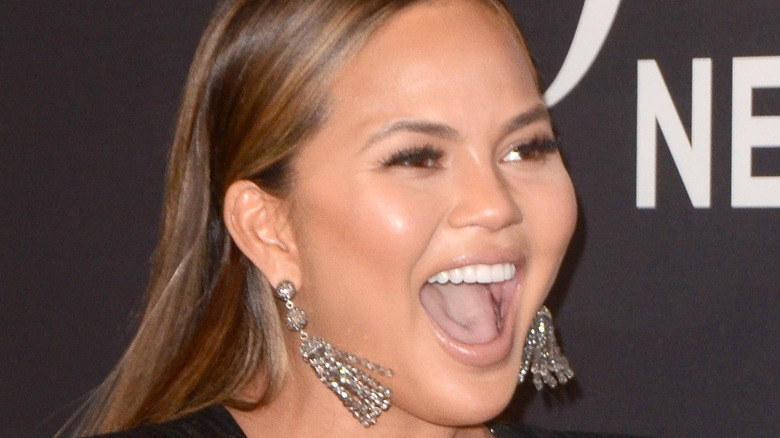 Chrissy Teigen has her mouth open laughing