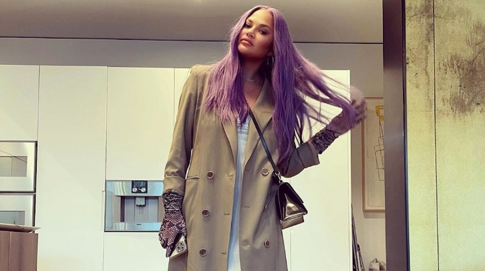 Chrissy Teigen posing with her purple hair