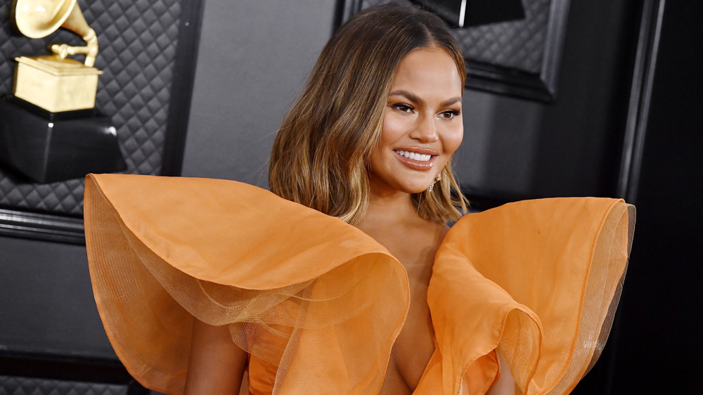 Chrissy Teigen posing on Grammy red carpet