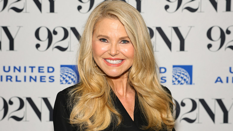 Christie Brinkley smiling at the camera, blonde hair slightly curled, black top.