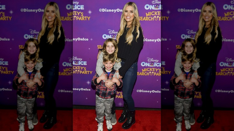 Christina Haack smiling on a red carpet with her two older kids