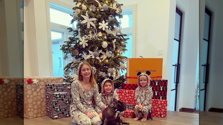 Taylor El Moussa, Brayden El Moussa, and Hudson Anstead in front of a Christmas tree