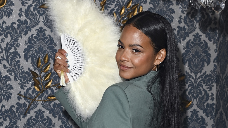 Christina Milian poses with a handheld fan